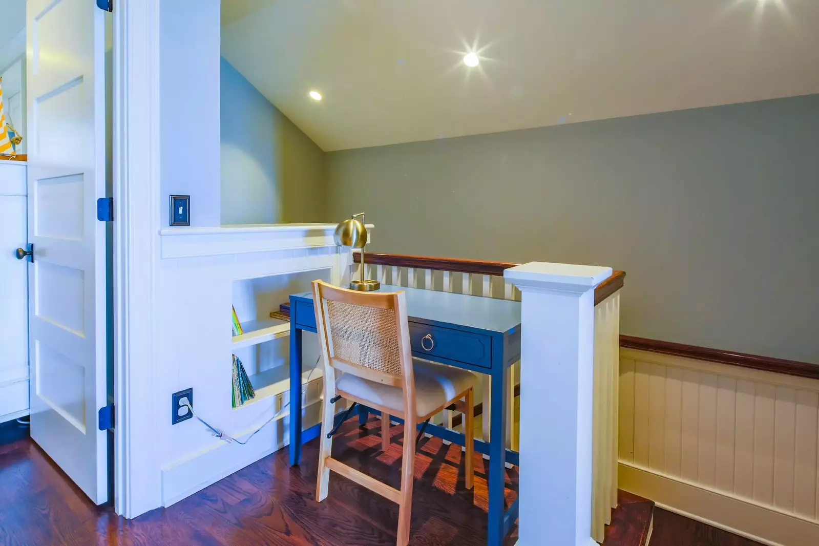 There is a desk at the top of the stairs on the second floor.