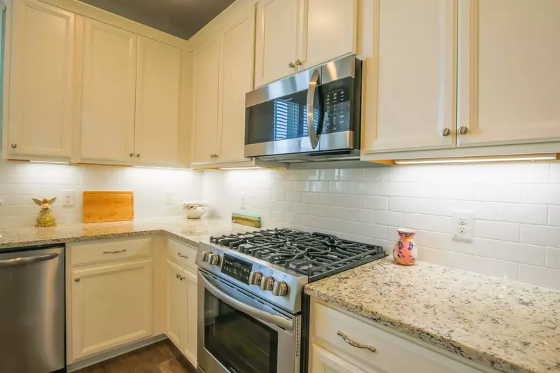 The kitchen features stainless steel appliances, including a gas stove, dishwasher and microwave.