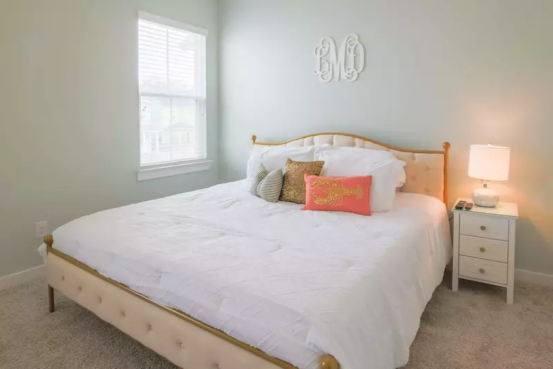 The master suite features a king bed and a night stand with a reading lamp.