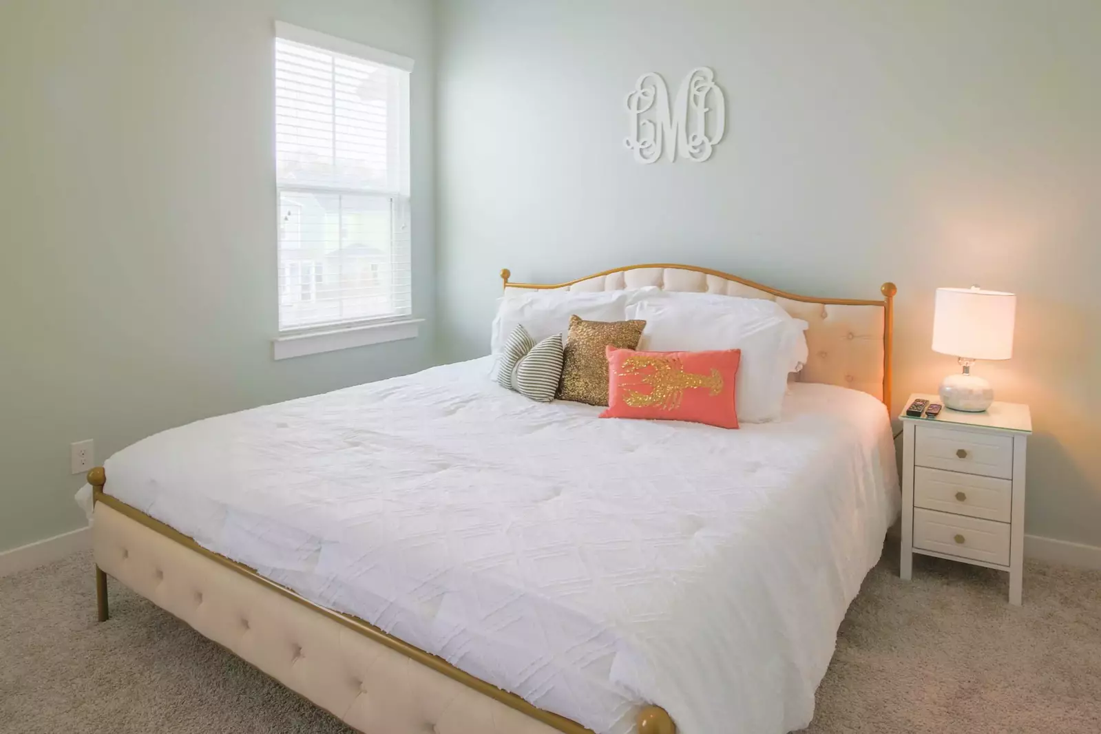 The master suite features a king bed and a night stand with a reading lamp.