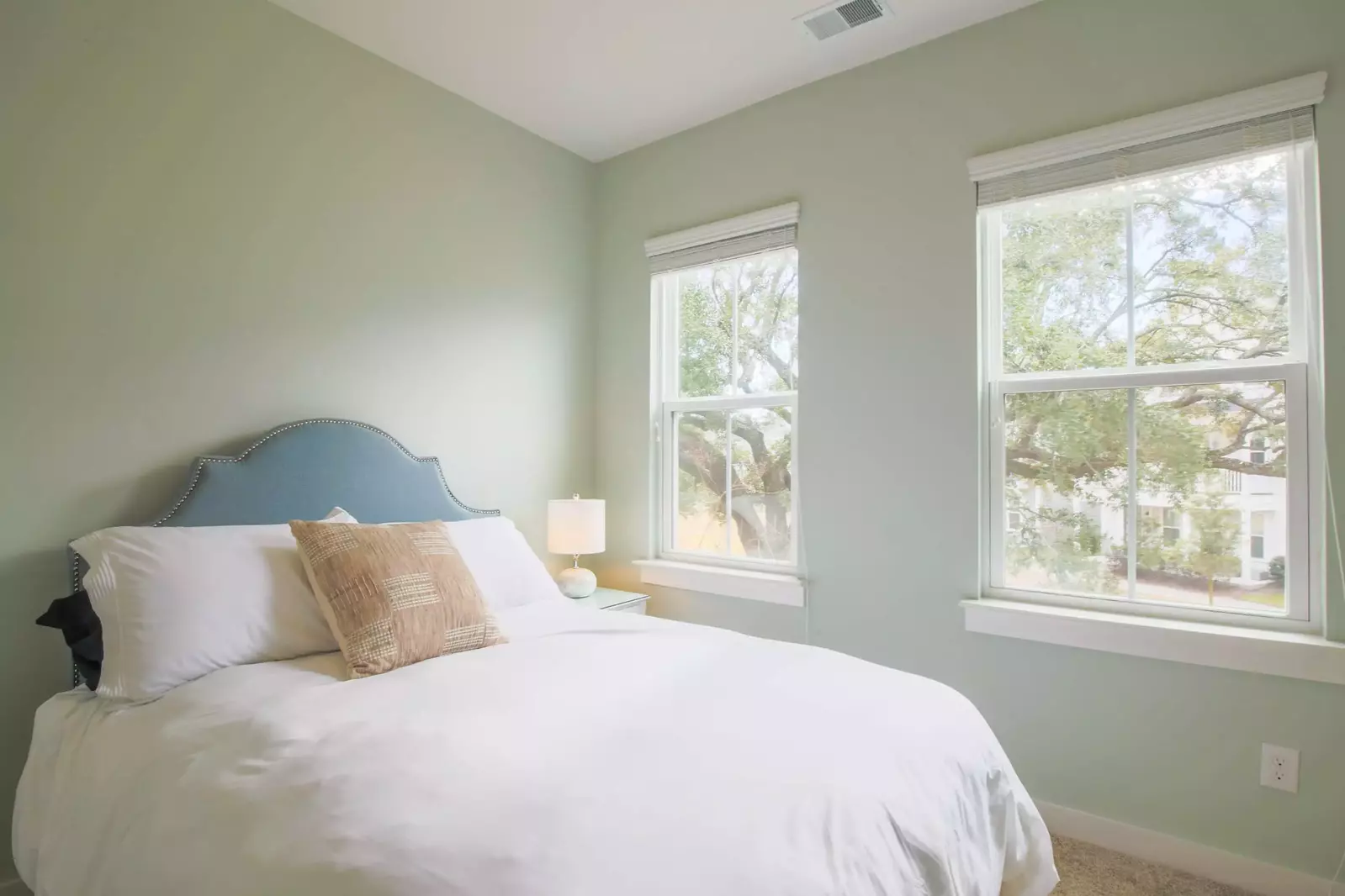 This guest bedroom enjoys lovely views of the live oak tree in front of the home.