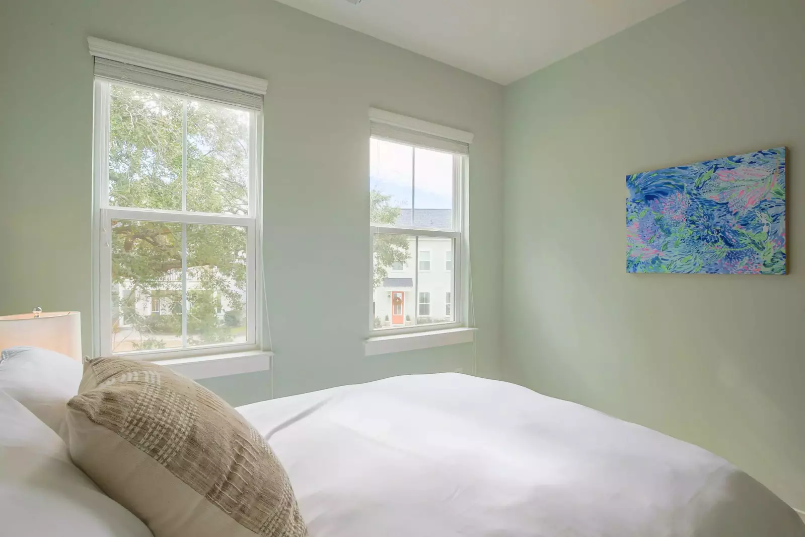 This guest bedroom receives lovely natural light through the two front windows.