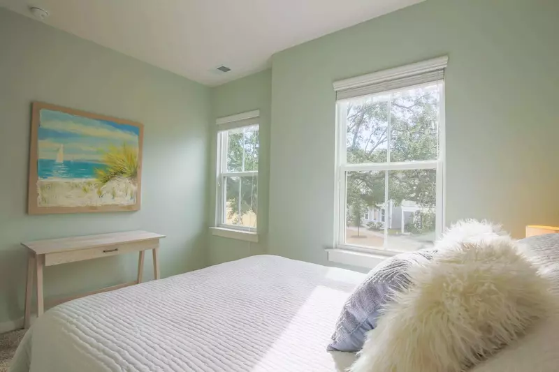 This guest bedroom also enjoys lovely natural light and views of the live oak in front of the home.