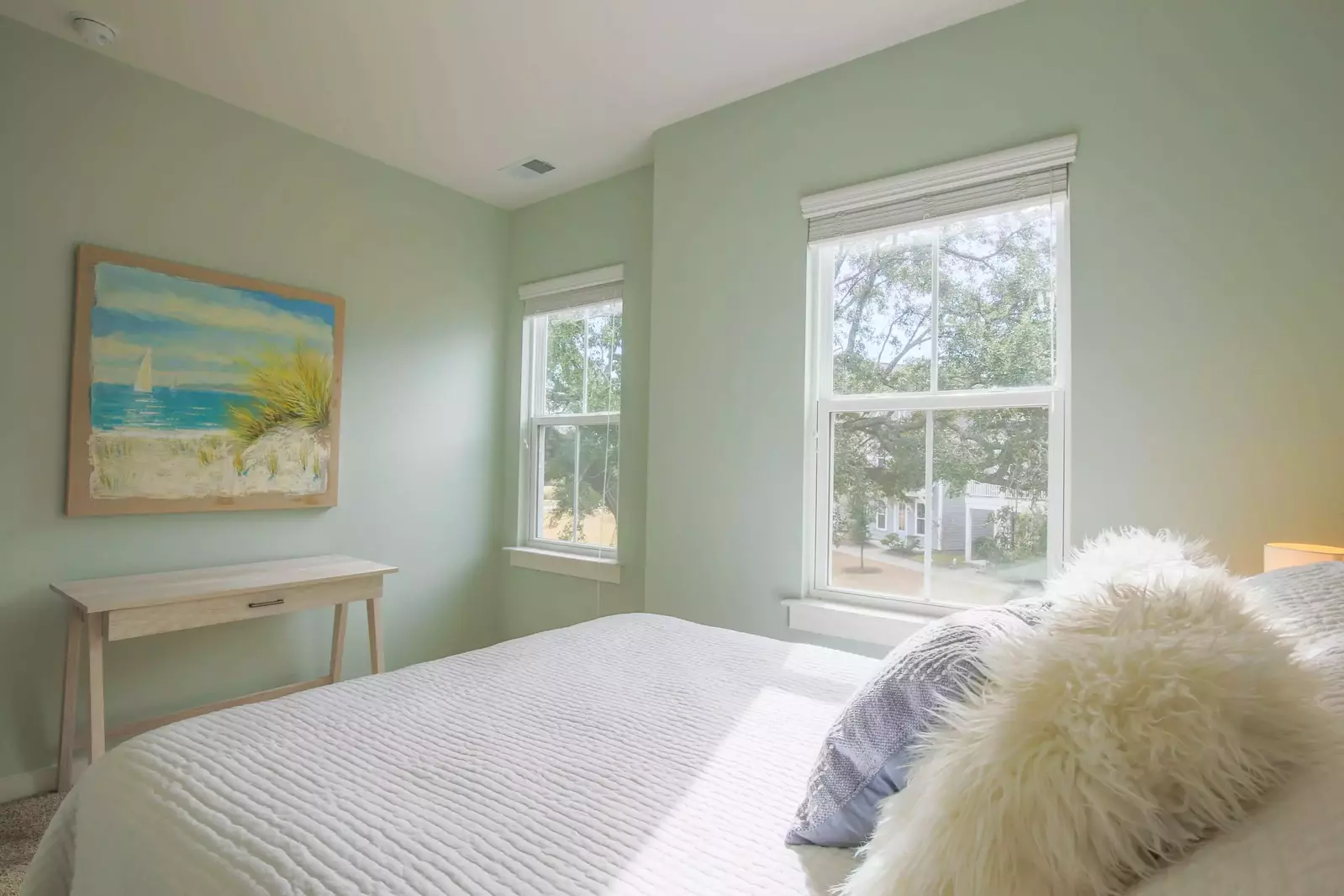 This guest bedroom also enjoys lovely natural light and views of the live oak in front of the home.