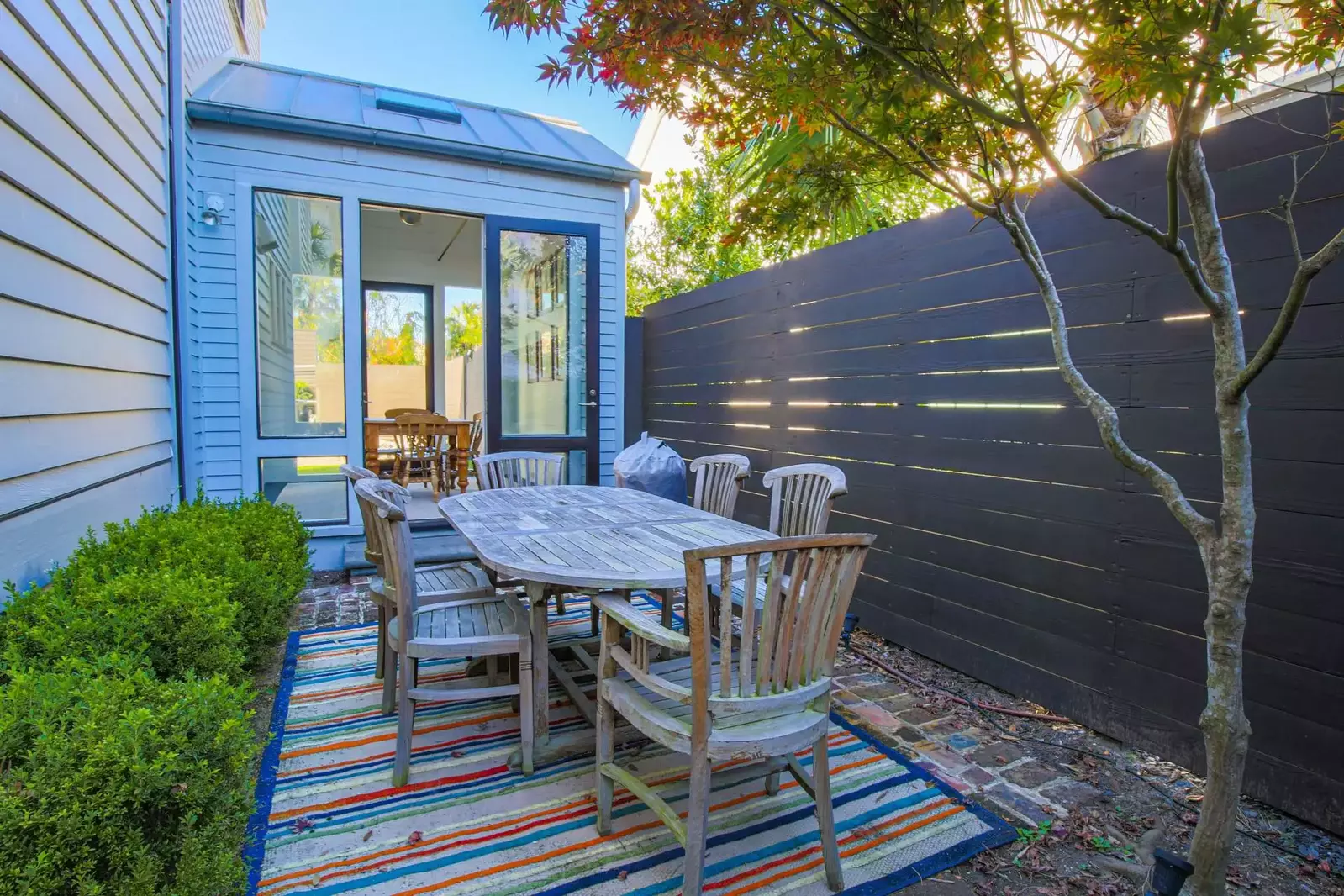 The private courtyard features a dining table that seats 6 and an electric grill.