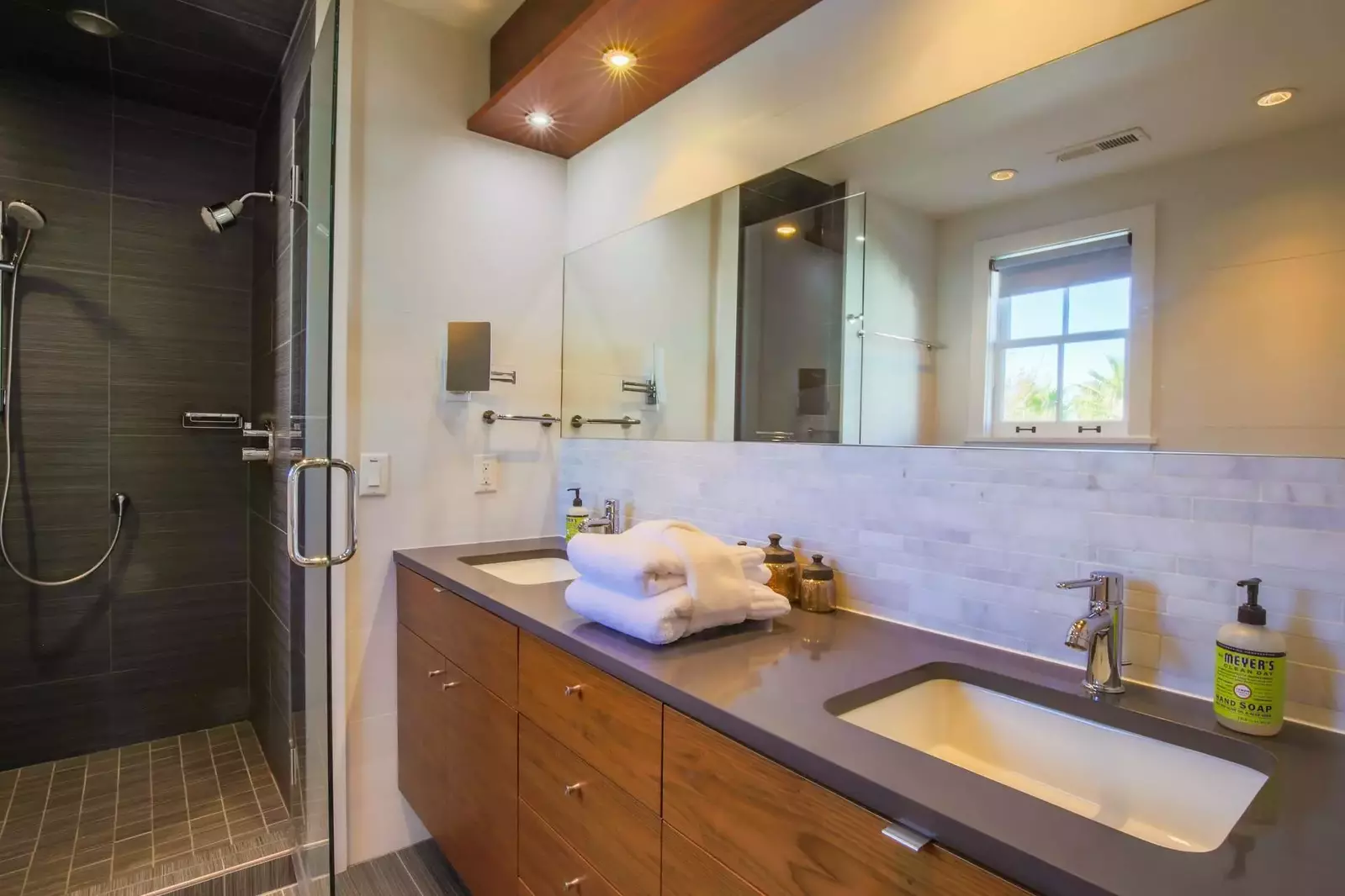 The en suite bathroom features two sinks, custom cabinetry and stunning tile work.