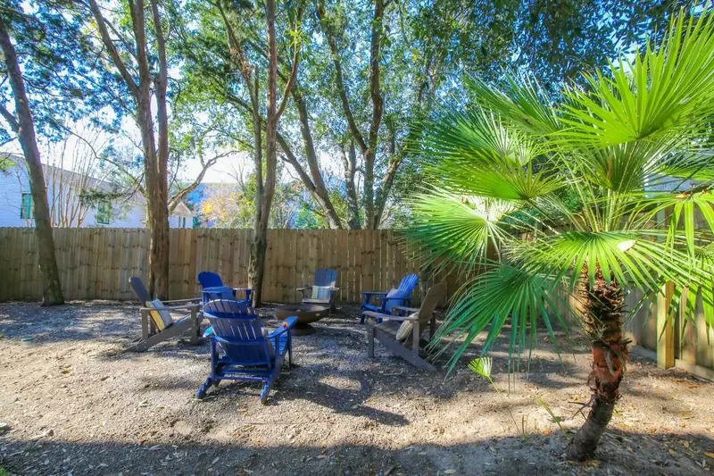 There are 6 Adirondack chairs and a fire pit in the backyard.
