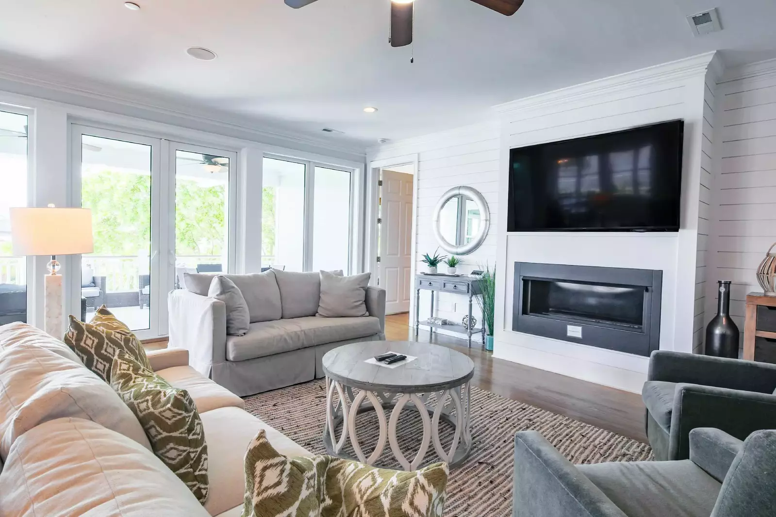 You'll find the living room with shiplap walls and mounted large screen TV on the second level of the home.