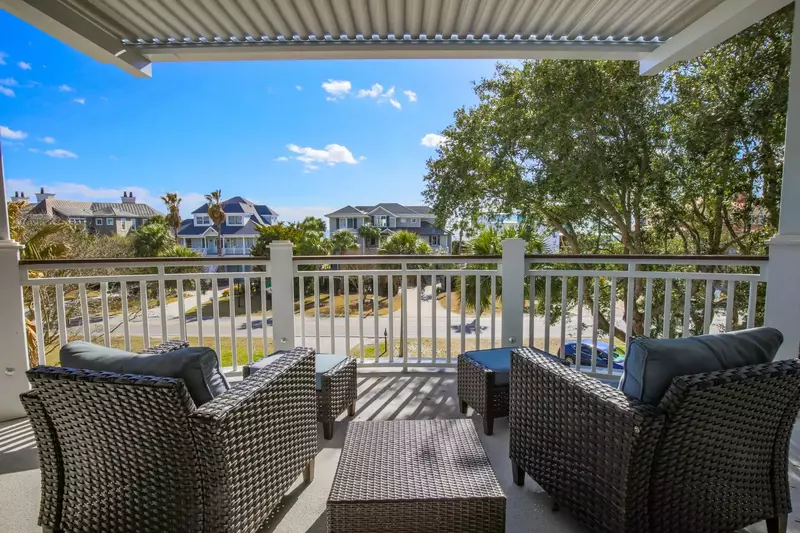 The covered balcony off of the living room features an outdoor seating area.
