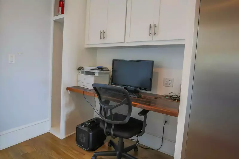 There is a desk & workspace near the kitchen.