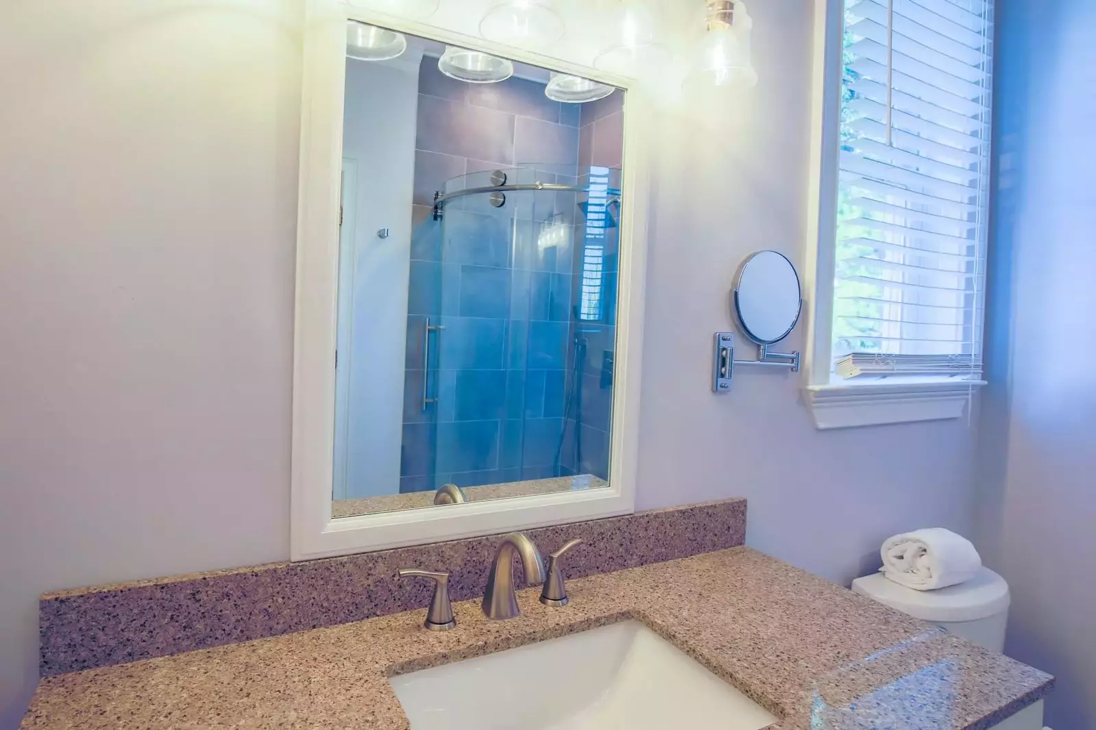 The en suite bathroom has a spacious vanity and tiled, walk-in shower.