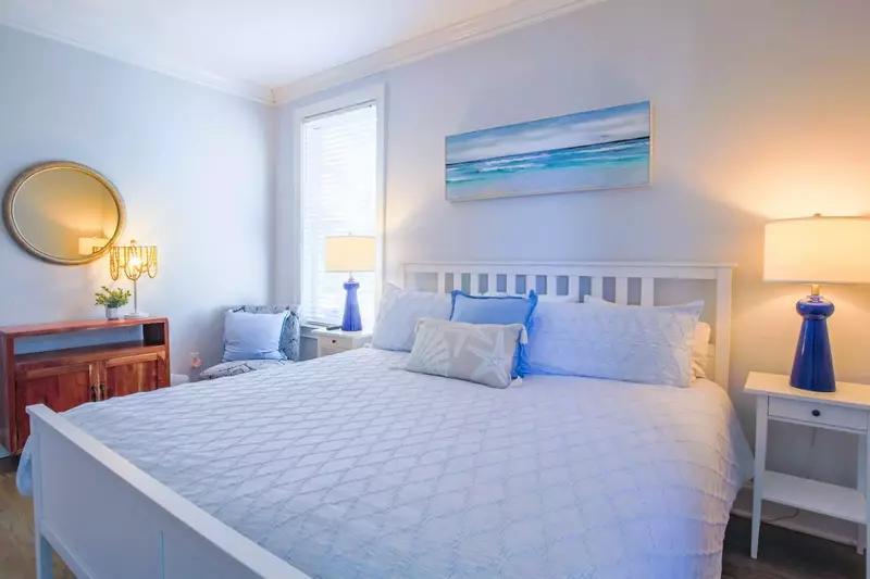This guest bedroom also features a chair, table and mirror.