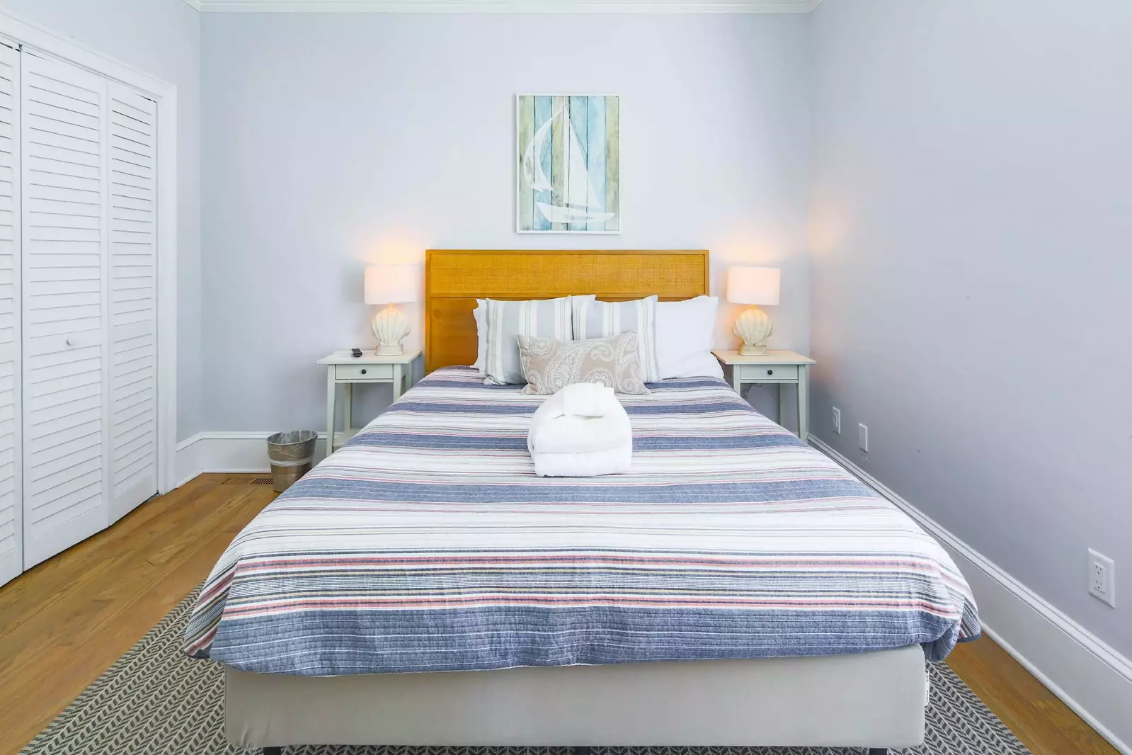 This bedroom on the first floor features a queen bed and night stands with reading lamps.
