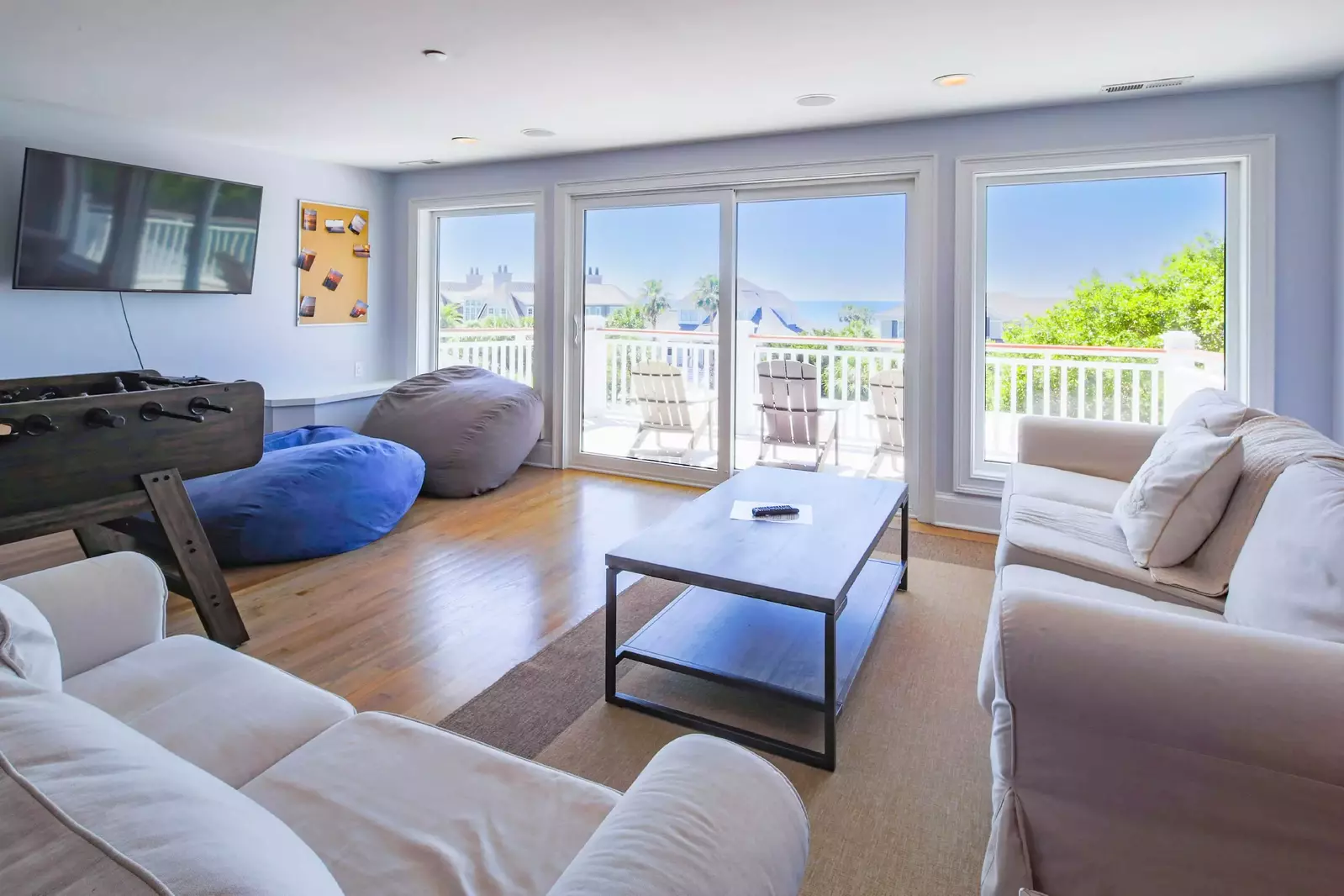 This third floor game room features ocean views and sliding door access to the balcony.