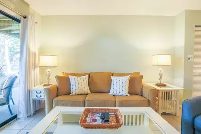 The living room features a queen sleeper sofa and sliding door access to the back patio.