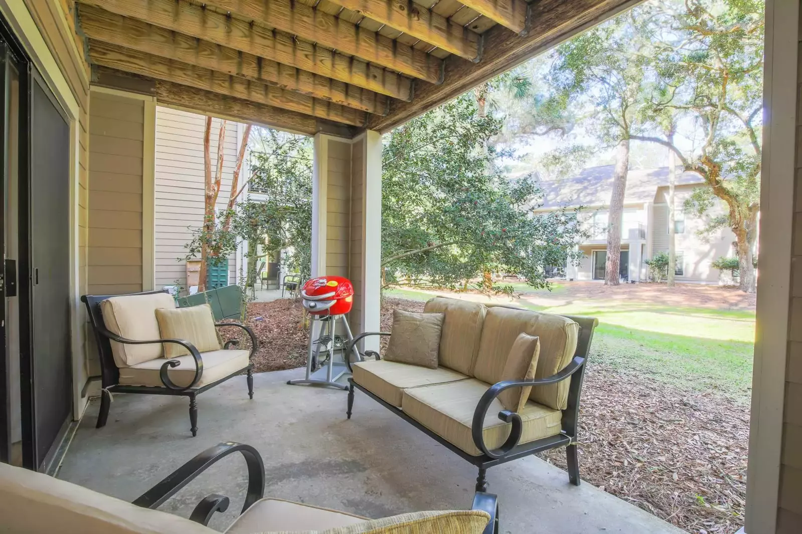 The back patio features an outdoor seating area and an electric grill.