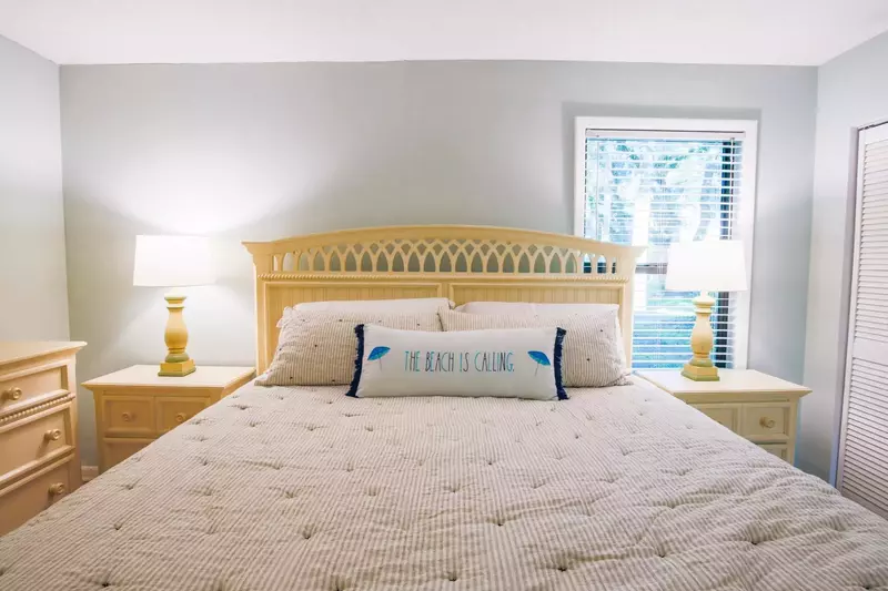 The master suite features a king bed, dresser and night stands with reading lamps.
