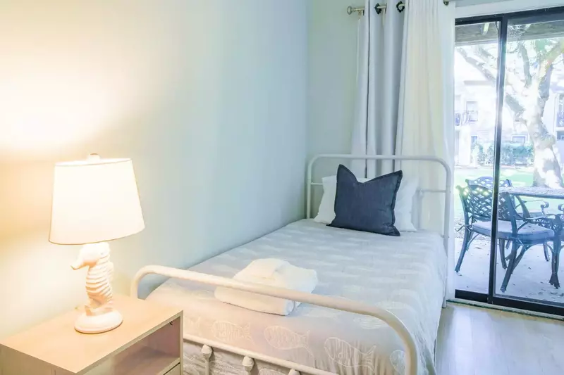 The guest bedroom features two twin beds and sliding door access to the back patio.