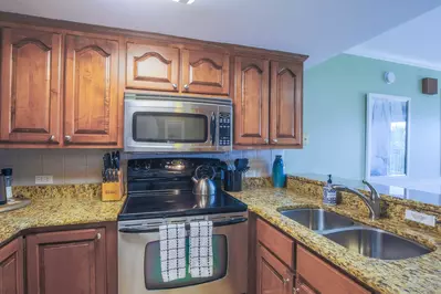 The kitchen features stainless steel appliances and granite countertops.