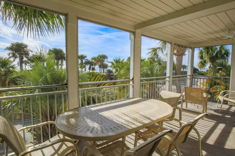 The screened balcony overlooks the ocean, palmetto trees and the Beach Club swimming pools.