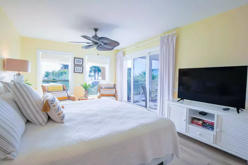 The master suite features a king bed, large screen TV and sliding door access to the screened porch.