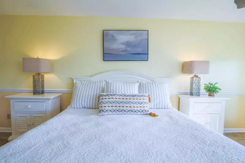 There is a night stand with a reading lamp on each side of the king bed.