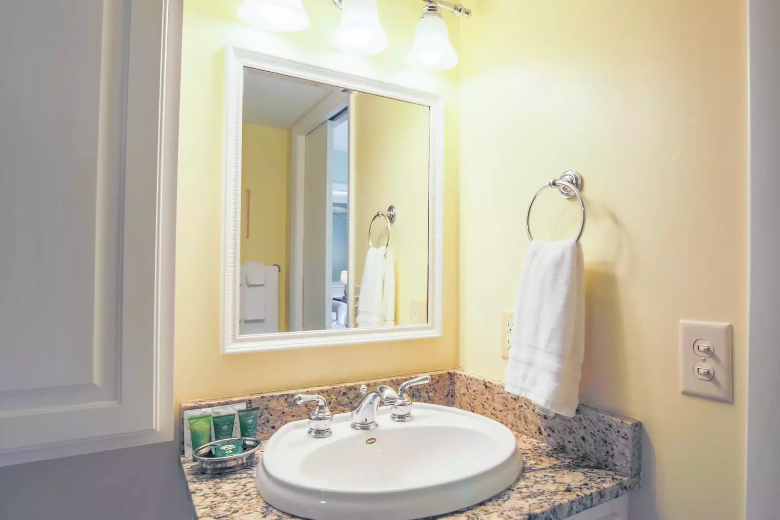 The master bathroom vanity has a granite counter and ample storage area.