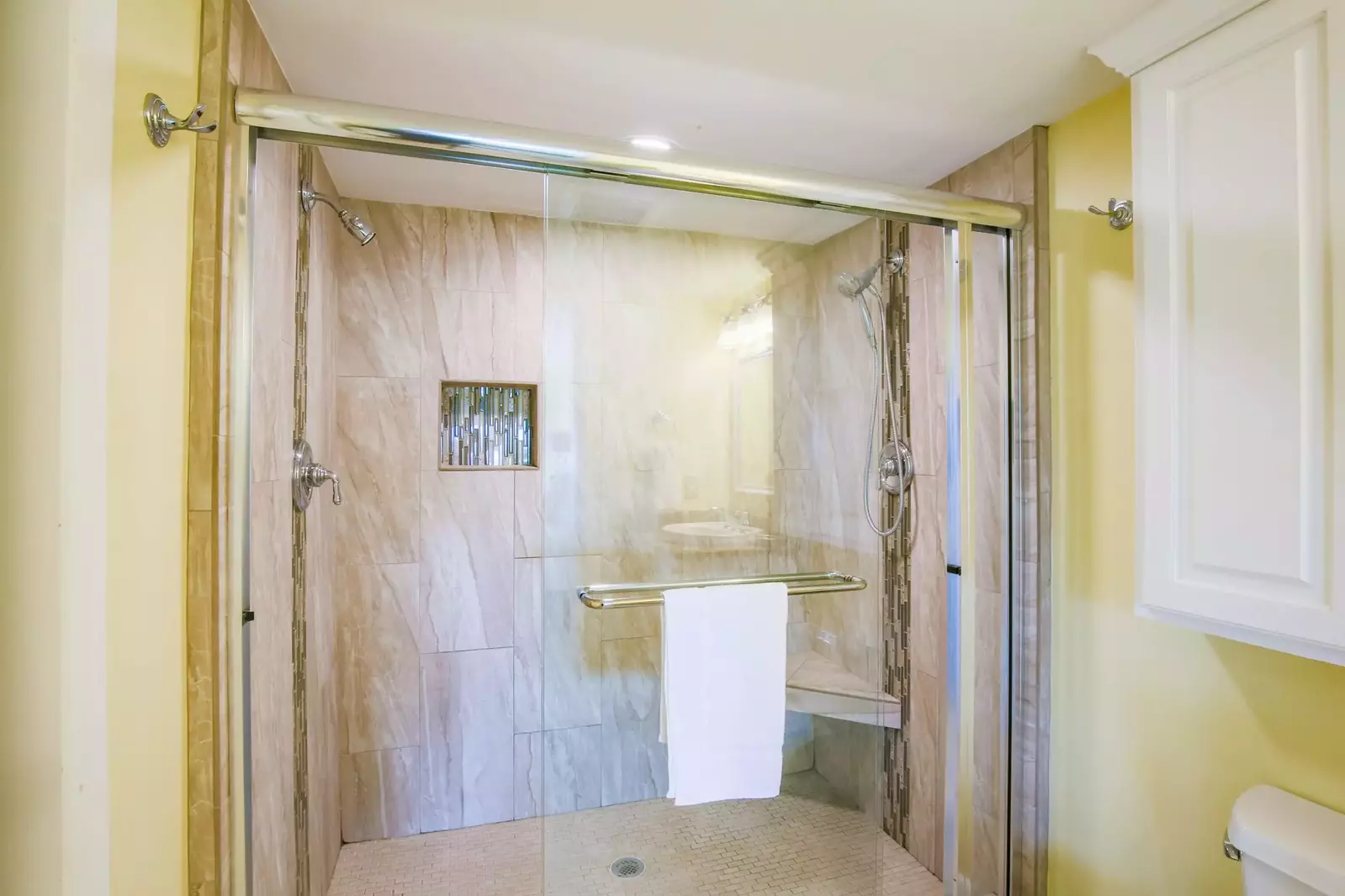 The tiled walk-in shower features two separate shower heads.