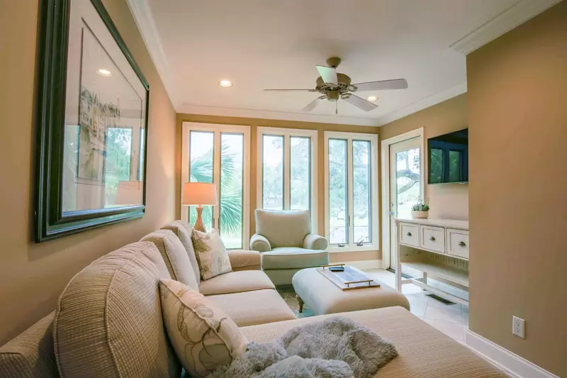 This seating area features a sectional sofa, arm chair, mounted smart TV and door to the back deck.