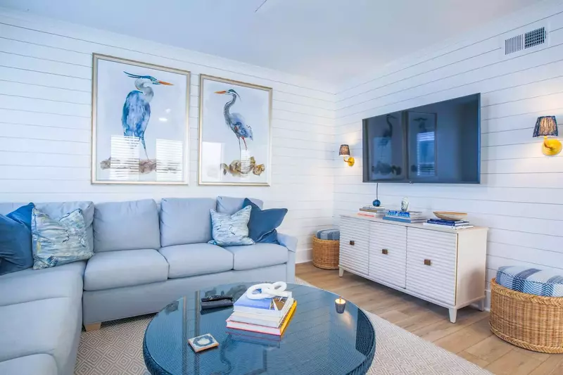 The living room features a large sectional, mounted smart TV and shiplap walls.