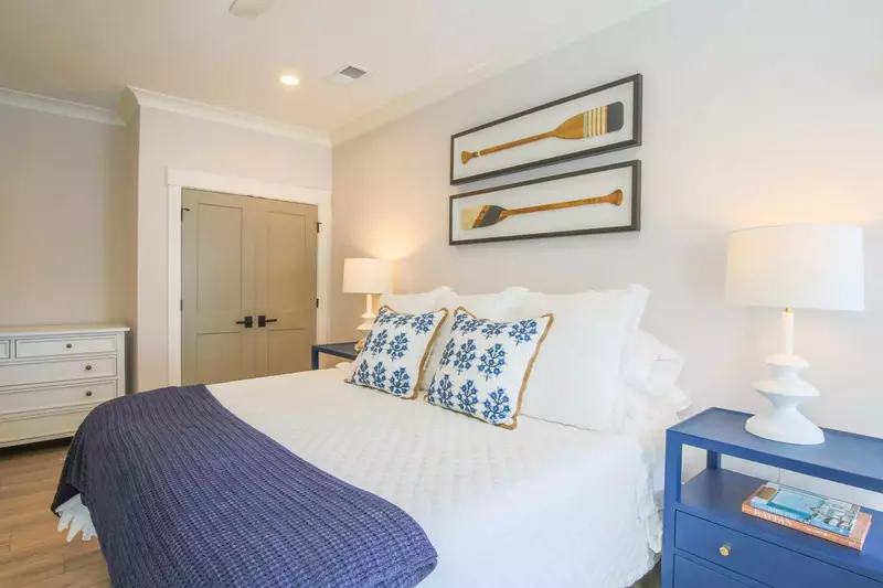 The second master suite features night stands with reading lamps and a dresser.