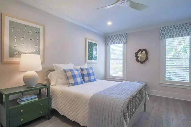 This guest bedroom features a queen bed and a night stand with a reading lamp.