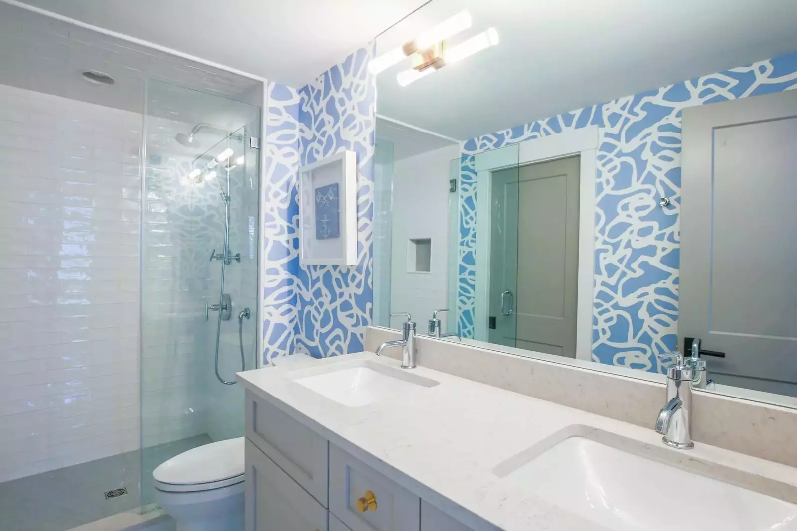 This bathroom features a double sink vanity and a tiled walk-in shower.