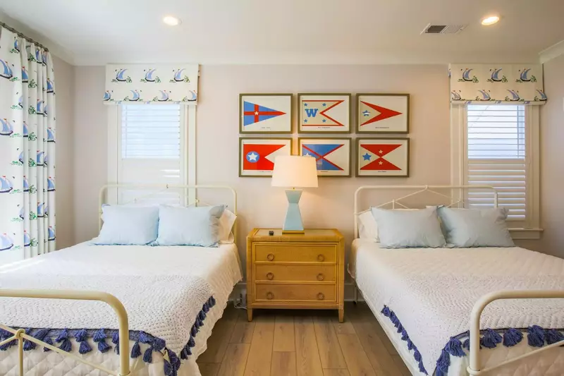 The two queen beds are separated by a night stand with a reading lamp.
