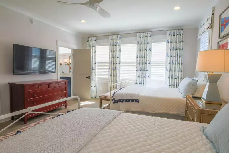 This guest suite also features a dresser, wall-mounted smart TV and an en suite bathroom.