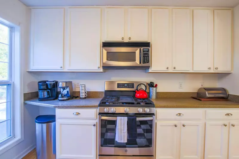 The kitchen features stainless steel appliances and white cabinetry.