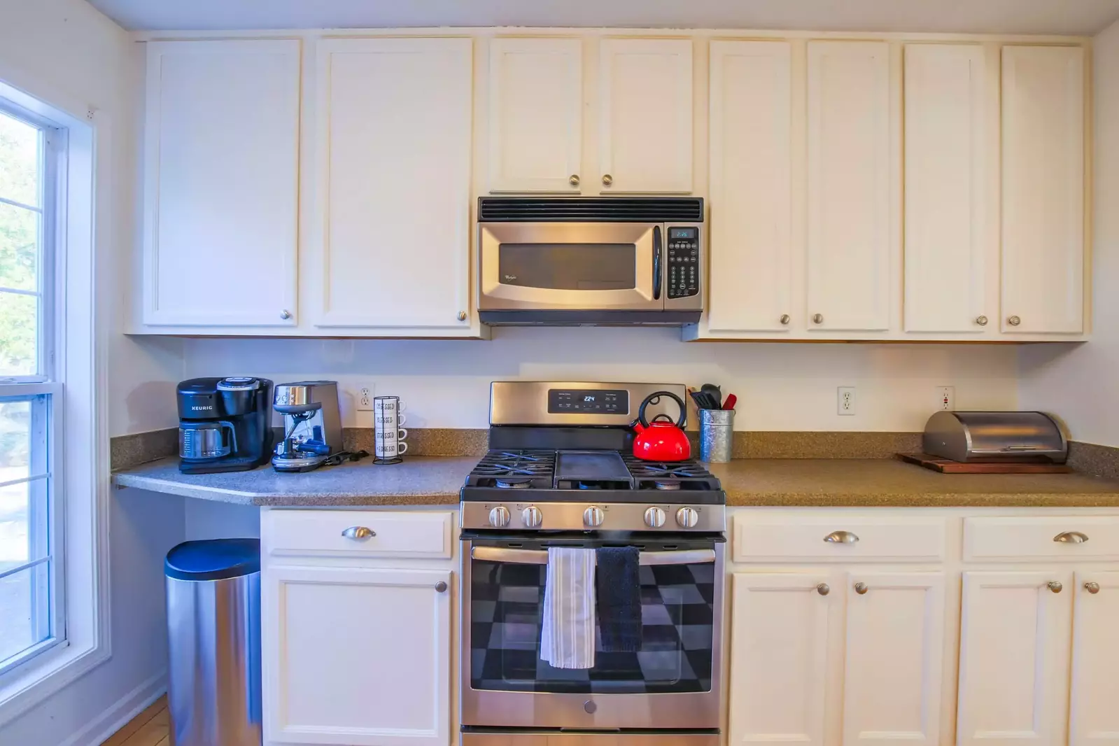 The kitchen features stainless steel appliances and white cabinetry.