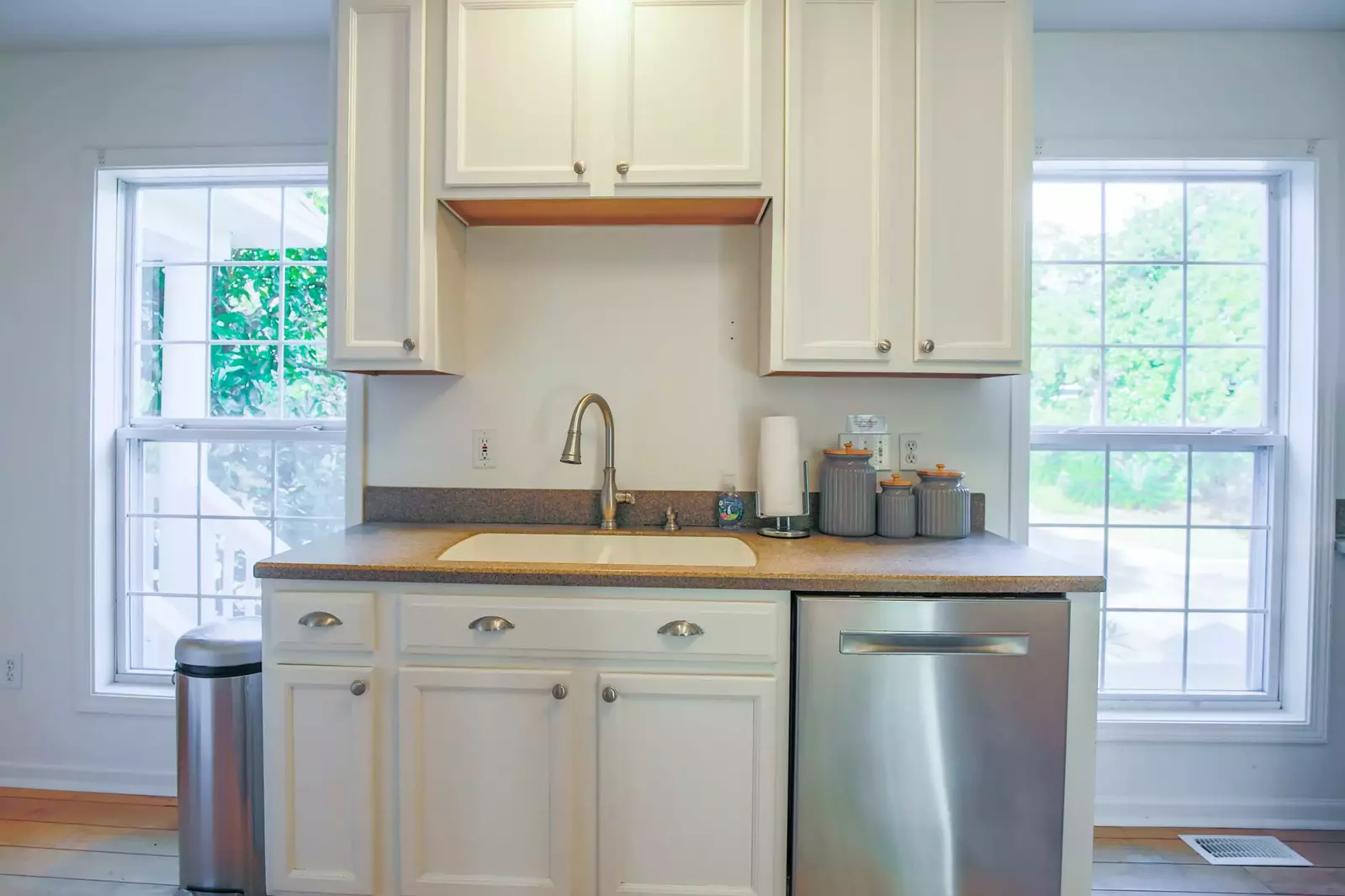 There is a dishwasher and a double sink with a garbage disposal.