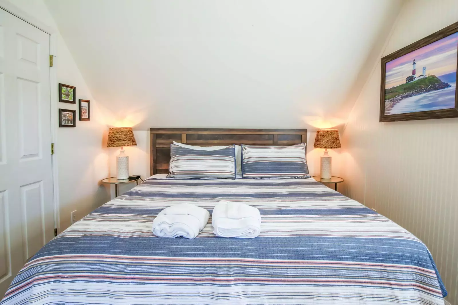 This upstairs king bedroom features night stands with reading lamps and beadboard.