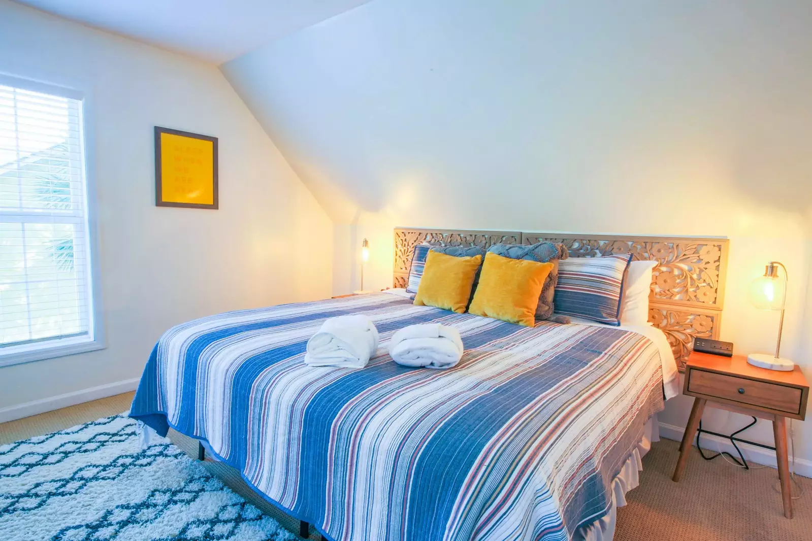 This upstairs bedroom also features night stands with reading lamps and a ceiling fan.