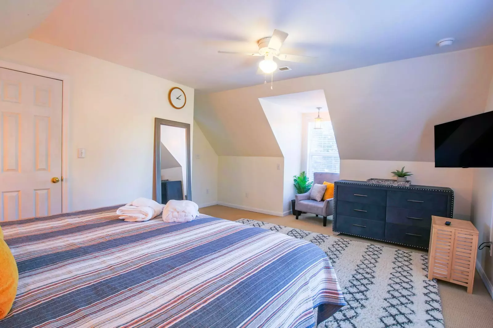 There is also an arm chair, dresser and full length mirror in this guest bedroom.