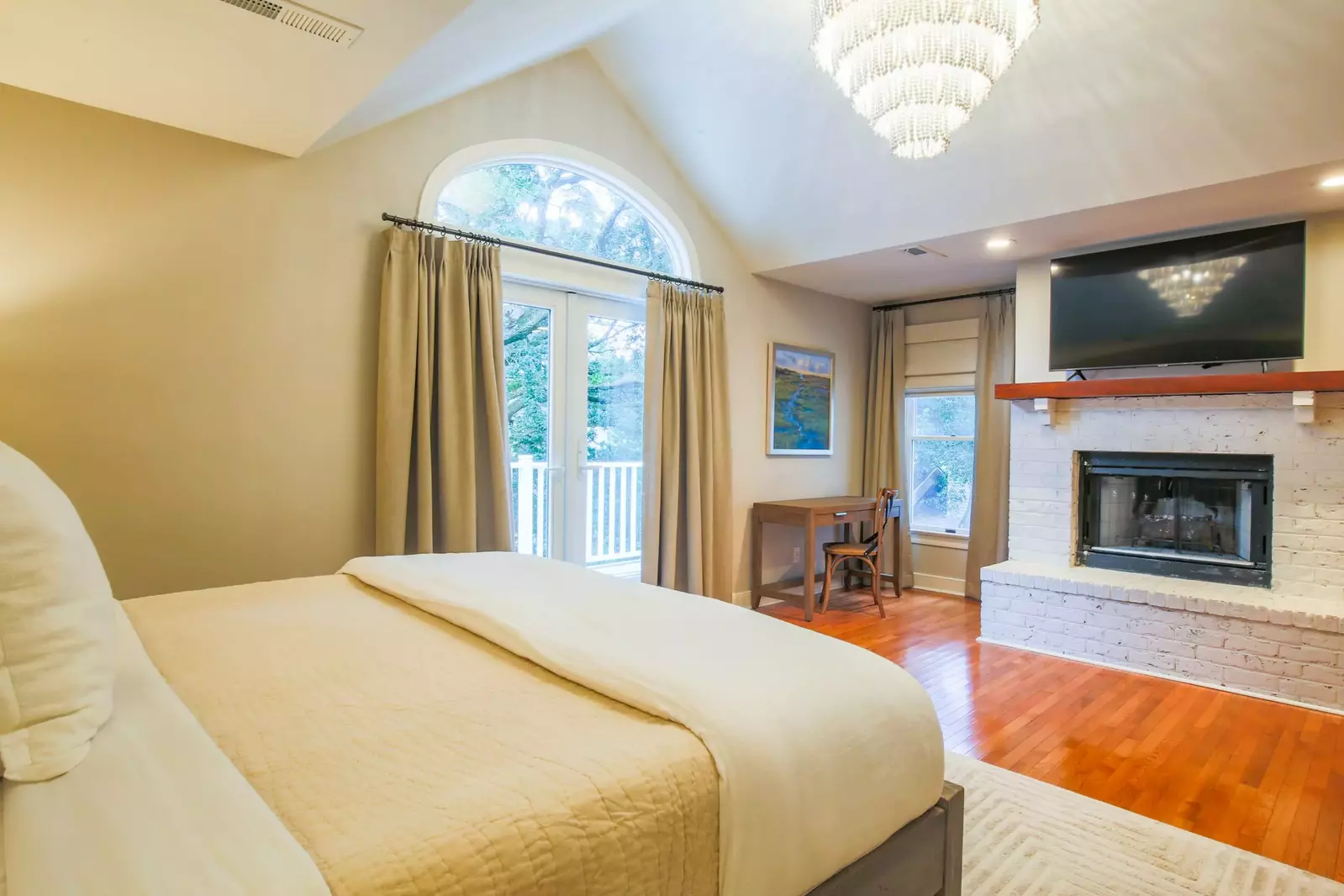 The master suite features a king bed, large screen TV, desk and access to an outdoor balcony.