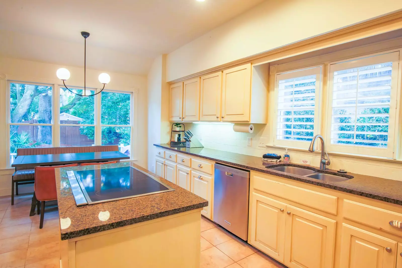 The kitchen also has a dining table with views of the backyard.