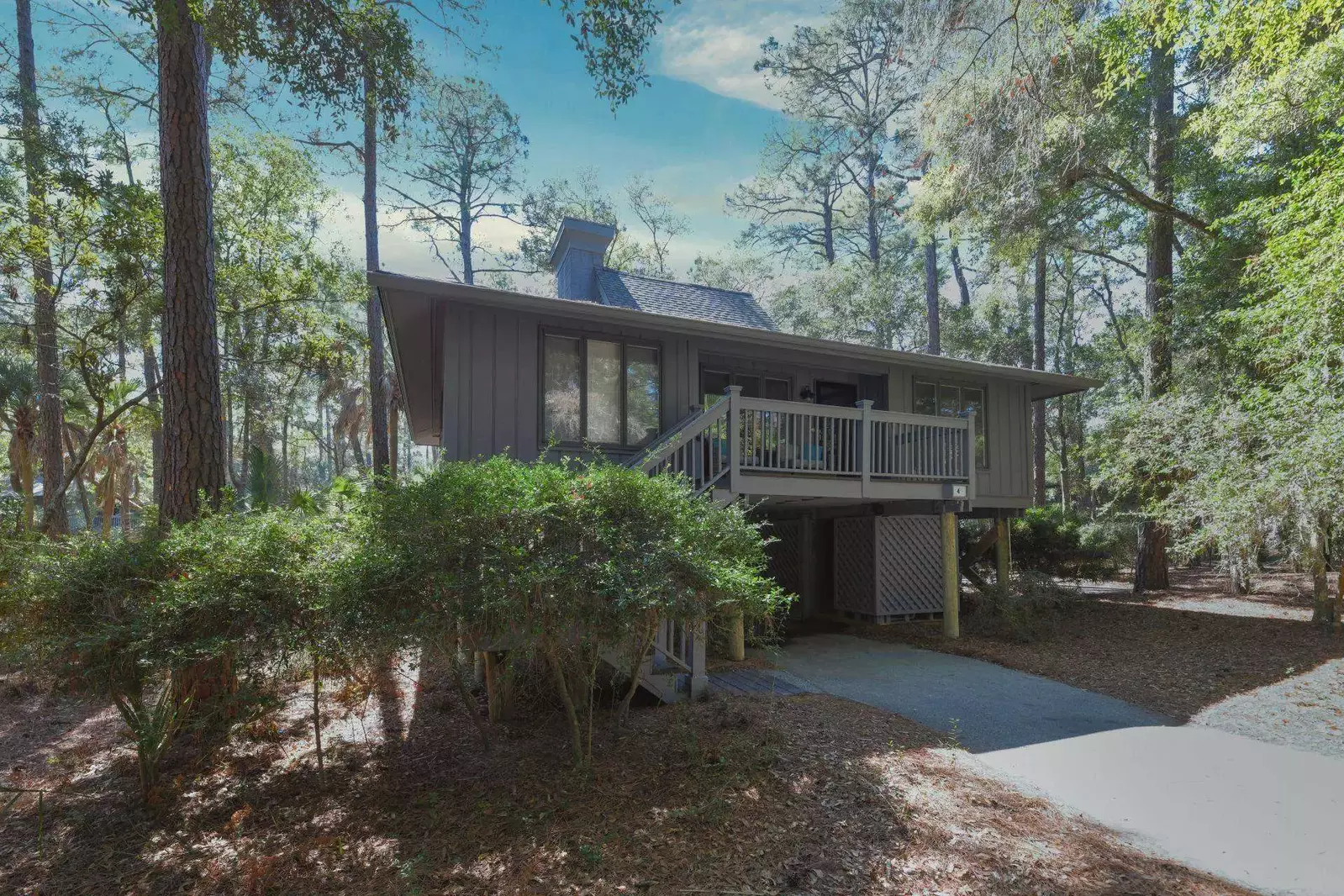 Riverhouse is an elevated home with a driveway and carport area beneath the home.