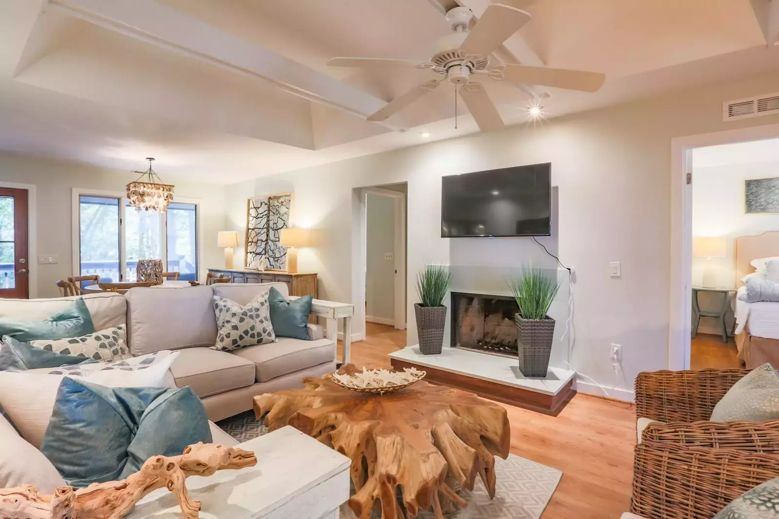 The living room also has vaulted ceilings, a ceiling fan and a wall-mounted smart TV.