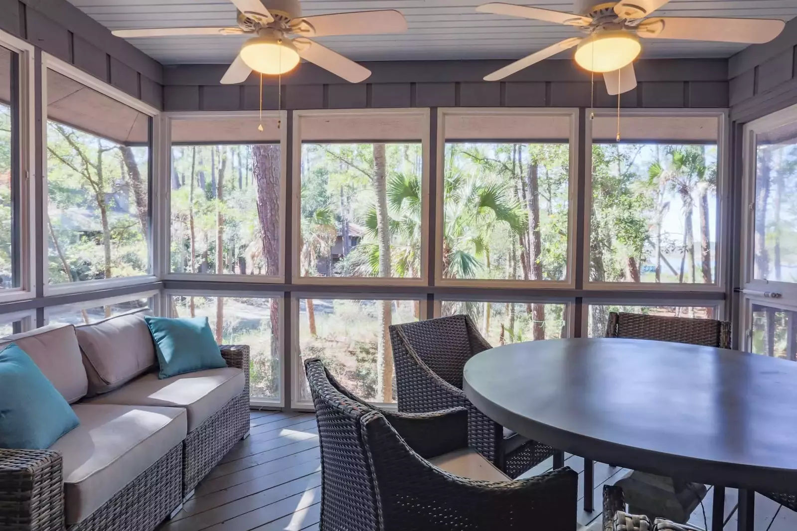 The screened porch features an outdoor sofa, a dining table & chairs and screen door access to the back deck.