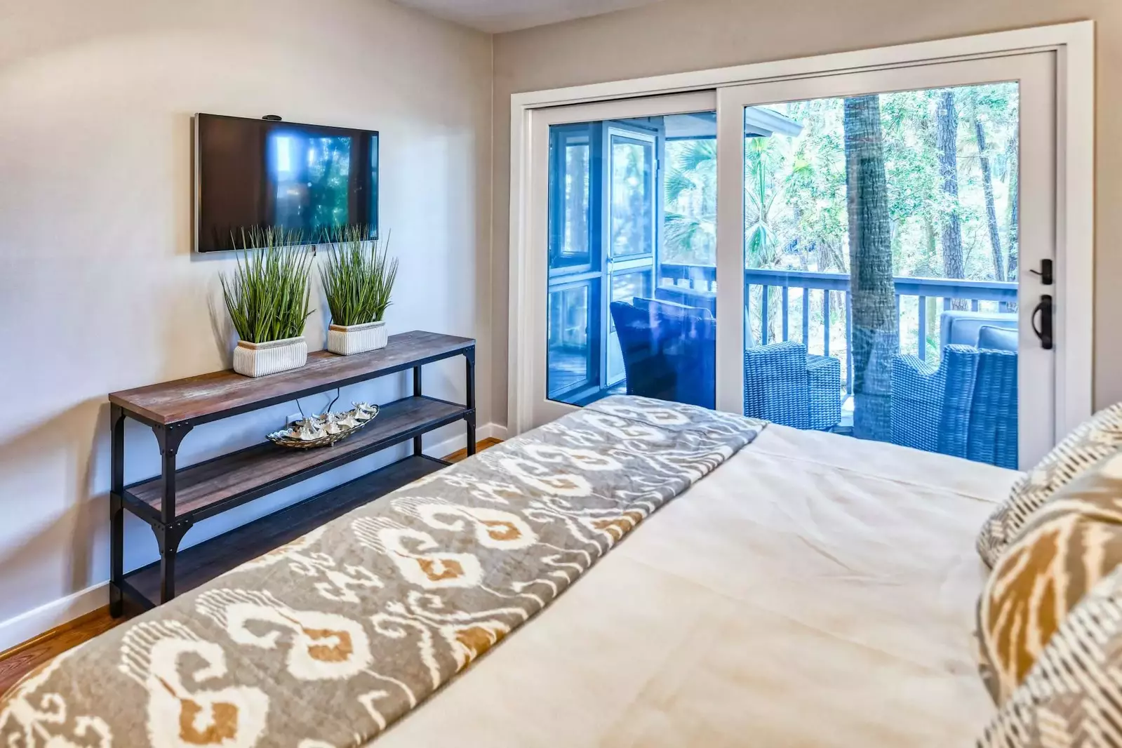 The master bedroom also has a wall-mounted smart TV and a ceiling fan.