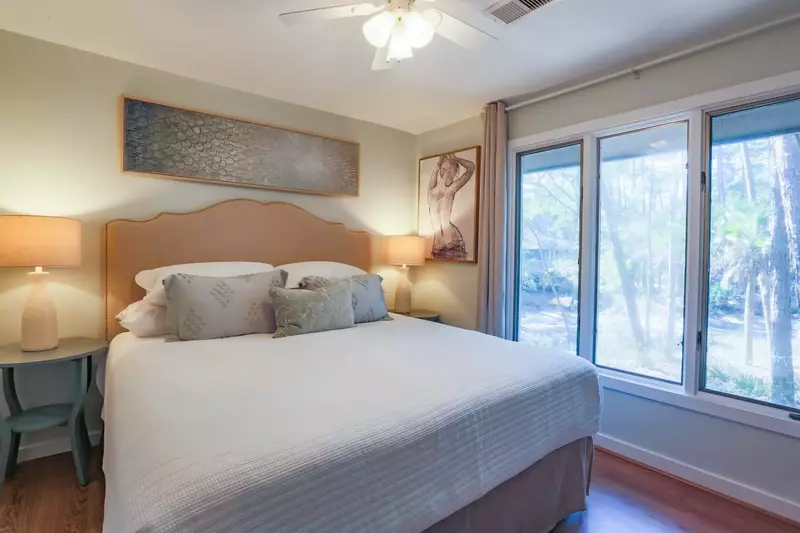 This guest bedroom features a king bed, hardwood floors and night stands with reading lamps.