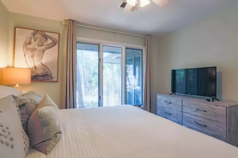 The guest bedroom also has a dresser, smart TV and a ceiling fan.