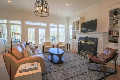 The living room features access to the screened porch and views of the Ocean Point community pool.